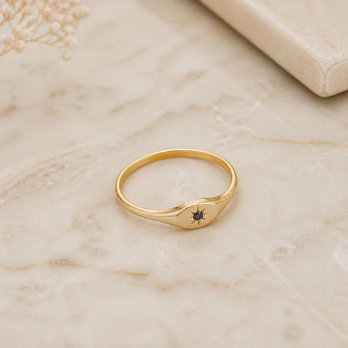Aurora Sapphire Signet Ring on ivory marble